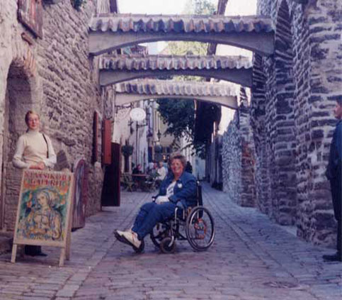Nancy travels Estonia> It's a bumpy ride in her wheelchair becauseof the brick roads but she loves every minute of it.